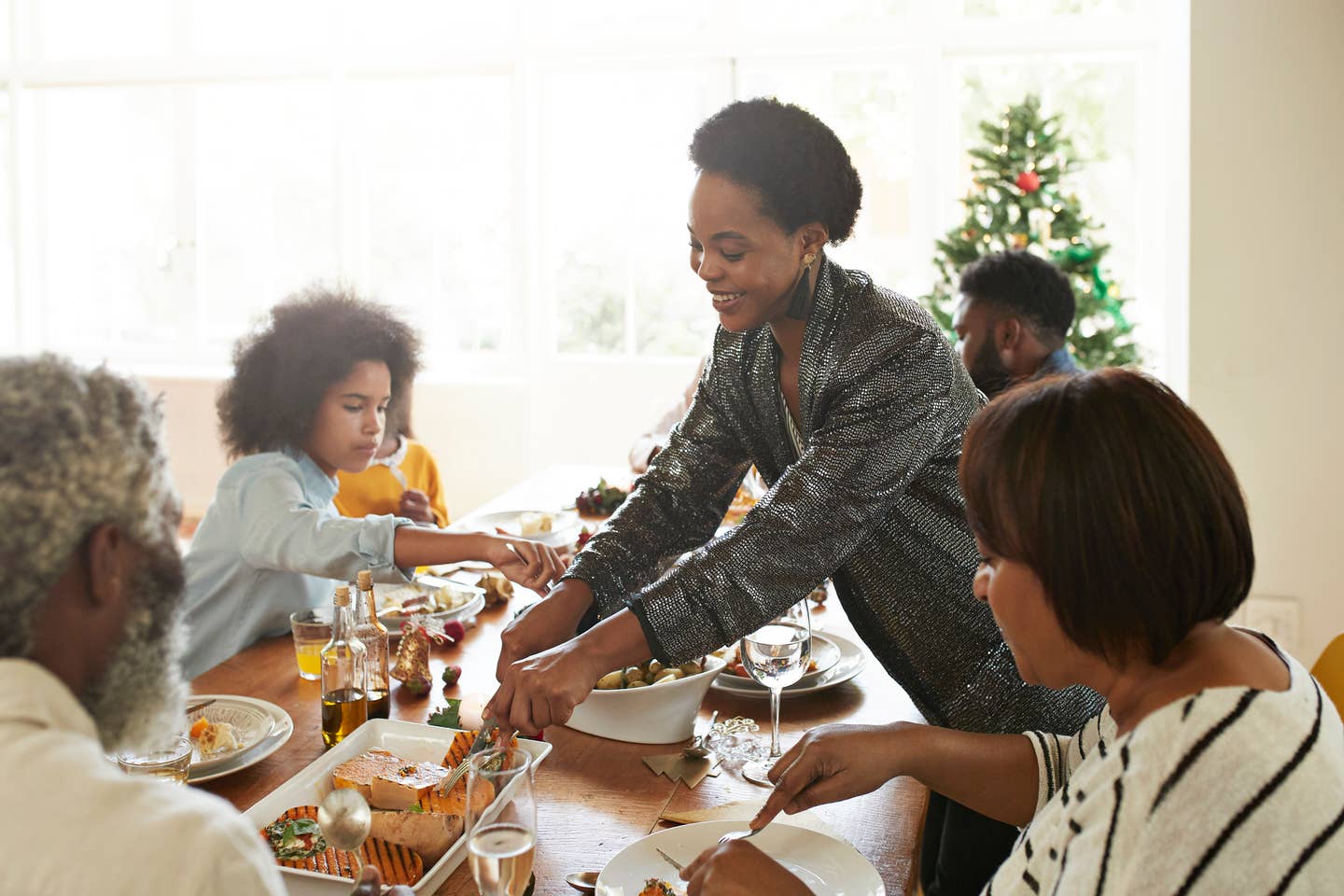 Young woman serving food to friends and family