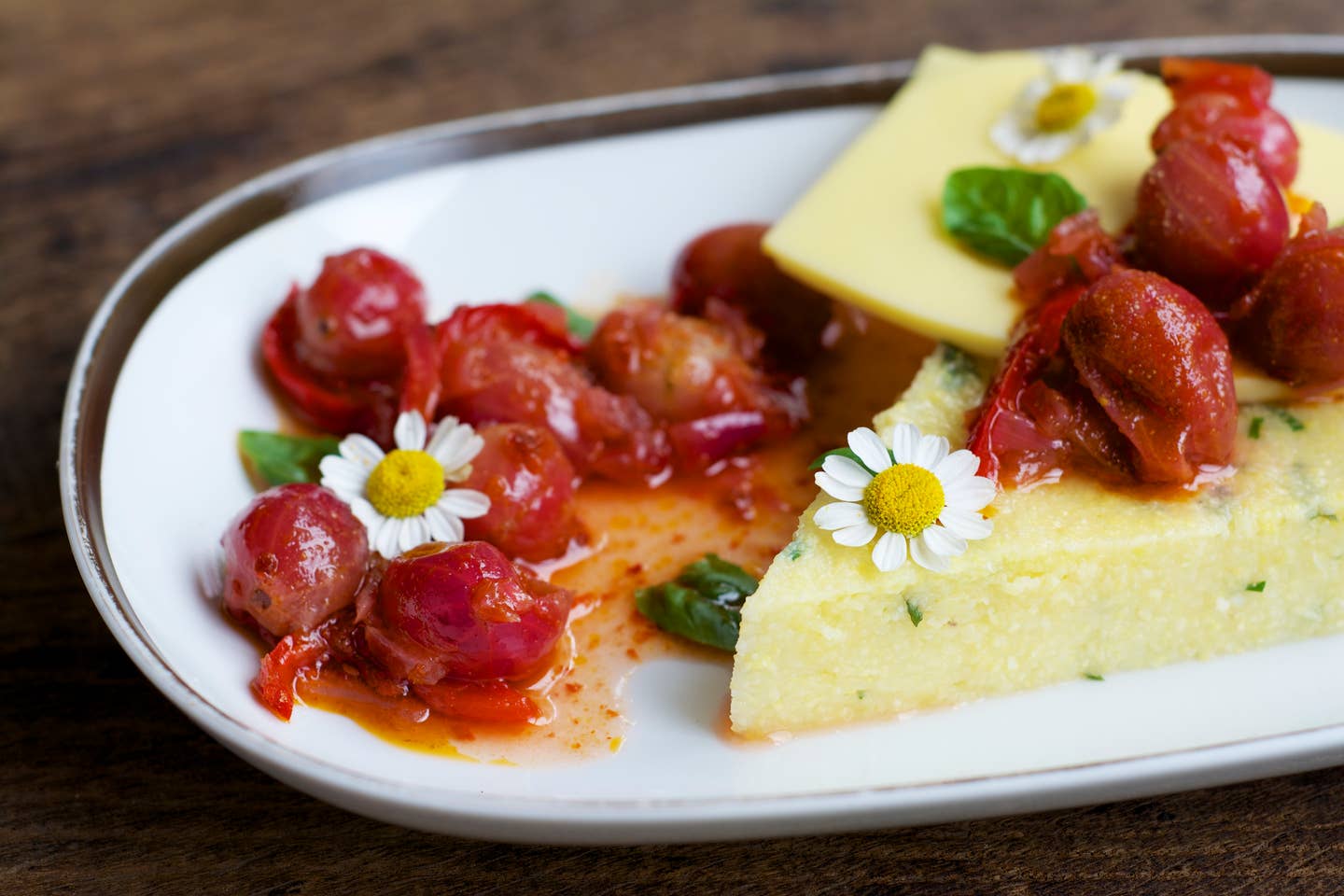 Platter of herbed polenta with vegan cheese, gooseberries and chili relish