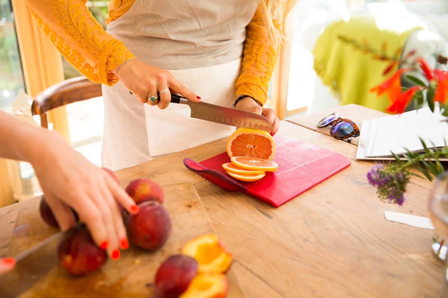 Hands of woman cutting oranges